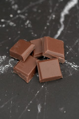 Milk chocolate pieces isolated on background from top view