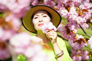 Portrait de femme au chapeau dans les fleurs de sakura