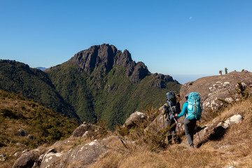 People walking with great backpacks in mountain landscape - trekking hiking mountaneering in...