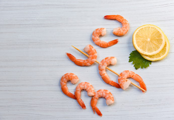 Seafood with shrimps prawns ocean gourmet dinner cooked with parsley lemon and skewers shrimp decorate on white wood background
