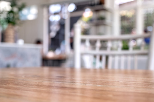 Wooden table and white chairs with blurred background in cafe