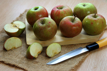 fresh apple on cutting board and a knife served on the table