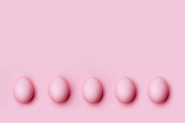 Top view of pink Easter eggs on pink background