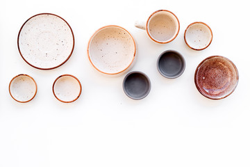 Ceramic tableware pattern. Empty plates and mugs on white background top view copy space