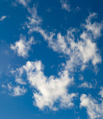 Smoky clouds float across a blue afternoon sky.