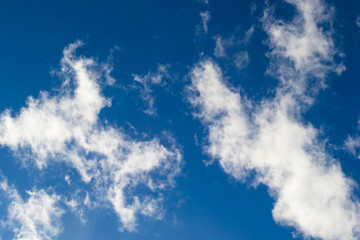 Obraz premium Smoky clouds float across a blue afternoon sky.