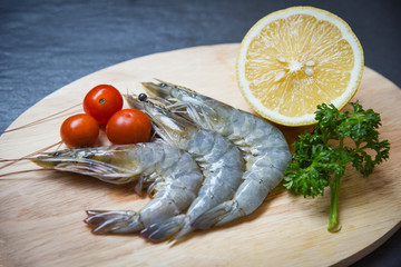 Seafood shrimps on cutting board / Fresh prawns ocean gourmet raw shrimp with tomato lemon and green parsley