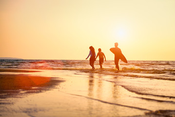Silhouette of Young surfers with brethren they're relaxing on sunset beach. Summer activity of...