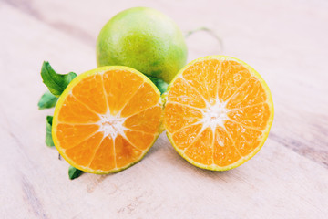 Fresh orange slice cut half harvest from the garden with leaf on wooden background