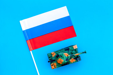 War, military threat, military power concept. Russia. Tanks toy near russian flag on blue...