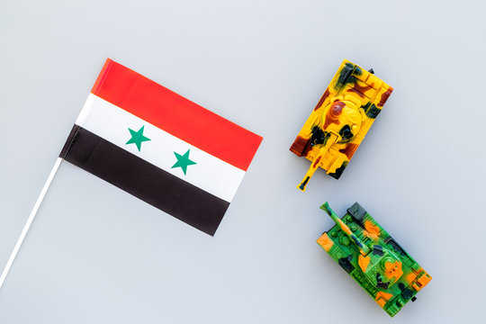 War, military threat, military power concept. Syria. Tanks toy near Syrian flag on grey background top view