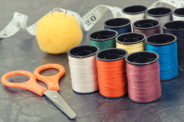 Accessories and tools for using in sewing. Spools of thread, needle, scissors and centimeter