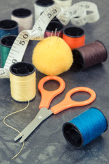 Accessories and tools for using in sewing. Spools of thread, needle, scissors and centimeter