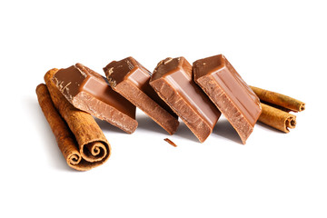 Tasty milk chocolate closeup with cinnamon sticks isolated on white background