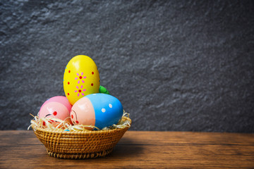 Easter eggs in the nest basket on rustic table wooden and dark background
