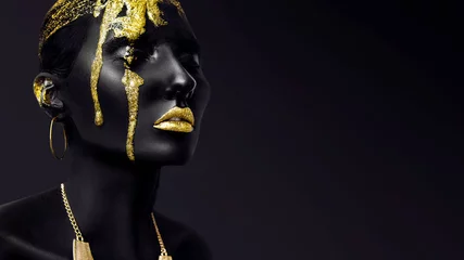 Foto op Plexiglas Jonge vrouw gezicht met kunst mode gouden make-up. Een geweldig model met zwarte en gele creatieve make-up. Close-up portret © Alena Gerasimova