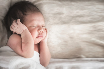 Newborn baby boy sleeping on its side with copy space.