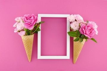 Flower card. Flower frame. Pink roses in an waffle cone and  white photo frame on a  fuchsia background. Flower ice cream.top view,copy space.Mothers Day. International Women's Day.	