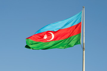 Flag of Azerbaijan flies against the blue sky