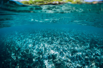 Fototapeta na wymiar Underwater view with stones and blue water.