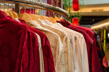 Obraz premium Colorful traditional chinese costumes hanging for sale during Chinese New Year.