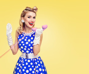 smiling woman with phone, dressed in pin-up style