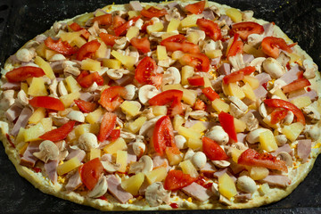 Cooking Hawaiian mushroom pizza with champignons, pineapple, tomatoes, cheese and cream sauce