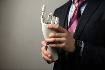 Man holds artificial limb for disabled people. Prosthetic arm.