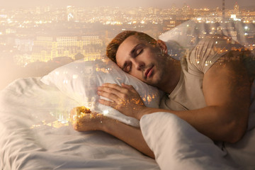 Double exposure of man sleeping in bed and city at night