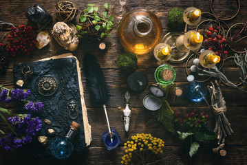 Spell book, magic potions and other various witchcraft accessories on the wizard table background. - obrazy, fototapety, plakaty