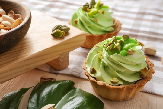 Tasty pistachio tartlet on wooden table