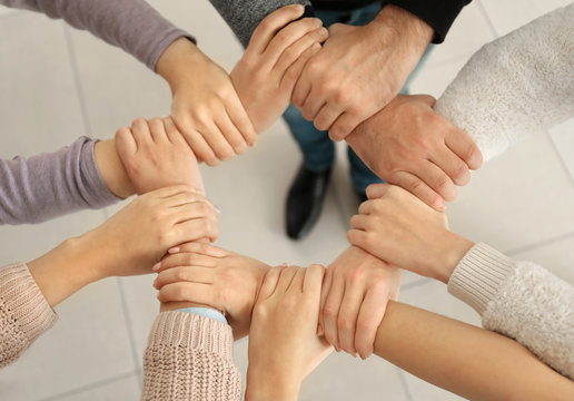People holding hands together as symbol of support