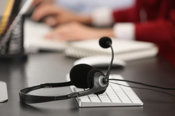 Keyboard with headset of technical support agent on workplace