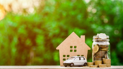 Grey miniature car model and coins on wooden table. - Finance and car loan, saving money for a car...