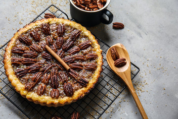 Cooling rack with tasty pecan pie on grey table