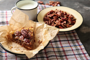 Tasty pecan pie with nuts and milk on grey table