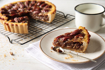Plate with tasty pecan pie on white table