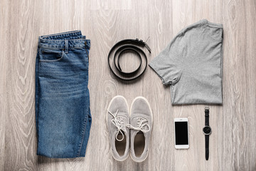 Stylish male clothes with accessories and mobile phone on wooden background