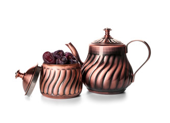 Tasty sweet dates in bowl with teapot on white background