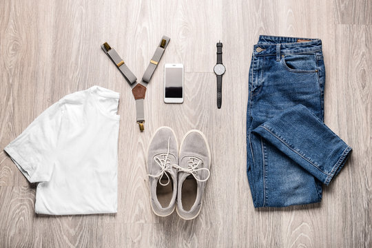 Stylish male clothes with accessories and mobile phone on wooden background