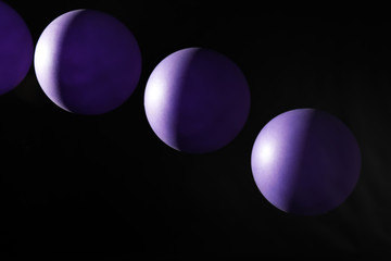 Stroboscopic photo of moving ball on dark background