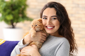 Young woman with cute funny cat at home