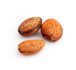 A pile of wild peeled almond nuts, closeup, isolated on white background.
