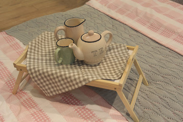 Teapot and coffee pot and interior decor on the bed with linen