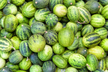 Top view of fresh ripe green small watermelons. Fruit background