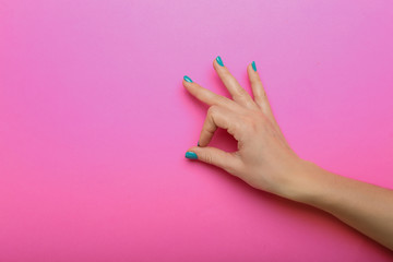 Female hand with beautiful manicure showing OK gesture on color background - obrazy, fototapety, plakaty