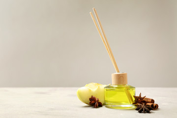 Reed diffuser, apple and spices on table