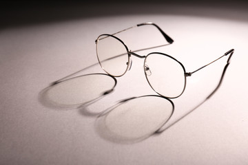 Stylish eyeglasses on light background
