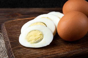 Boiled eggs on dark wooden background.