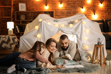 Happy family reading book at home